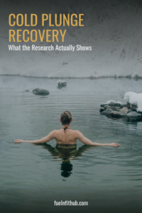 Woman submerged to the shoulders in a calm winter lake, back turned, illustrating cold plunge recovery